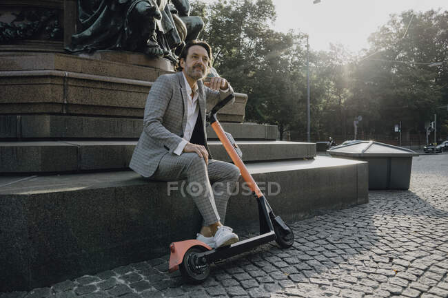 Empresario con e-scooter en la ciudad - foto de stock