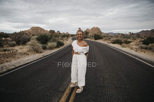 Happy woman standing on road, Joshua Tree National Park, Californie, États-Unis — Photo de stock