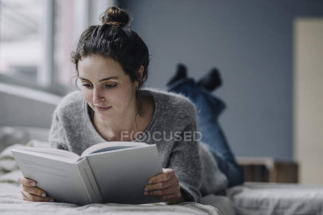 Портрет молодої жінки, яка читає книжки вдома. — стокове фото