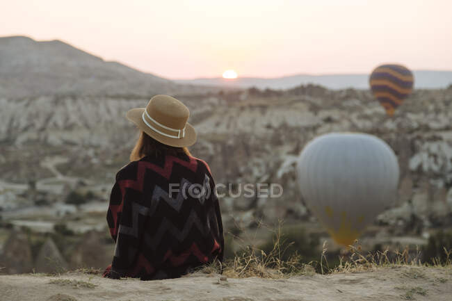 Young woman and hot air balloons in the evening, Goreme, Cappadocia, Turkey — Stock Photo