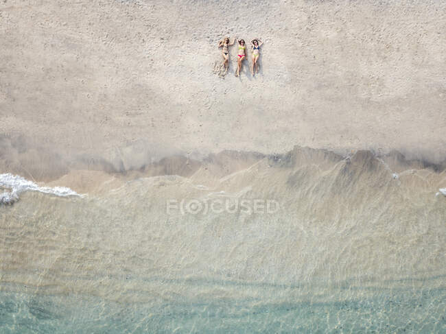 Aerial view of young women lying at the beach, Gili Air island, Bali, Indonesia — Stock Photo