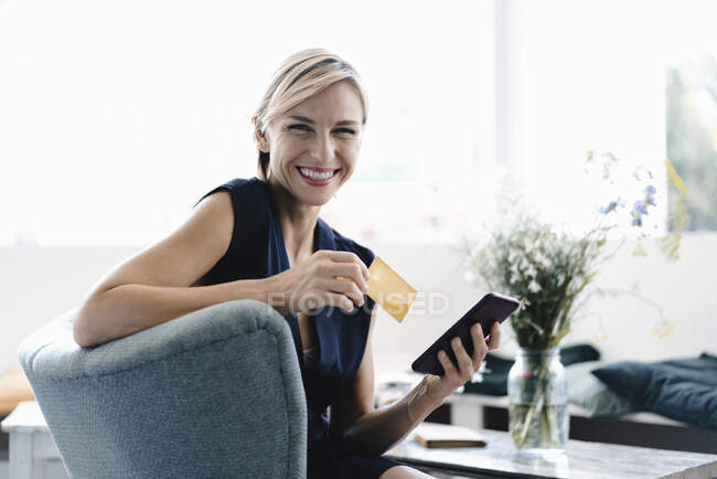 Зайнята жінка робить онлайн-оплату, використовуючи смартфон і кредитну картку в кав'ярні — стокове фото