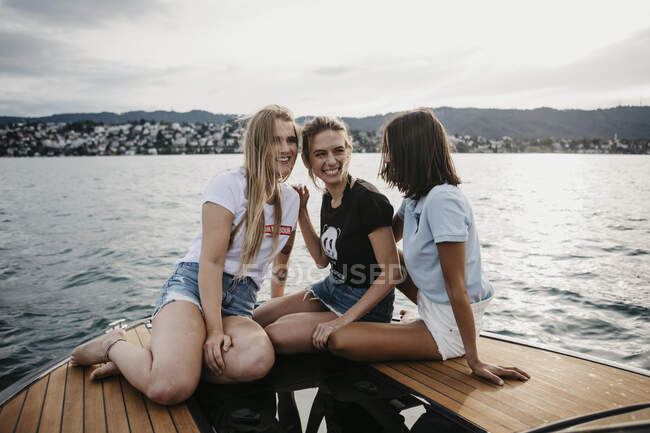 Щасливі подружки бавляться на човні на озері. — стокове фото