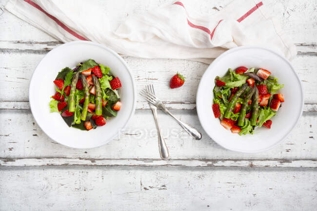 Direkt über dem Blick auf frischen Salat in Schüsseln mit Gabeln und Serviettenholztisch — Stockfoto