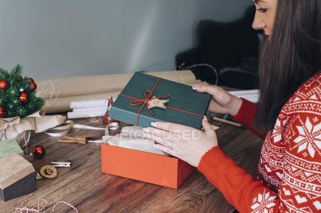 Woman's hands decorating Christmas present — Stock Photo