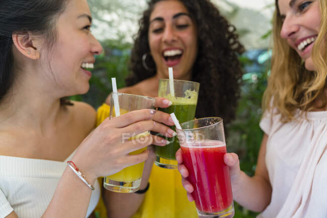 Trois jeunes femmes heureuses grillant avec des boissons saines — Photo de stock
