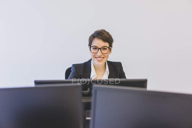 Порти усміхненої молодої бізнес-леді за столом в офісі — стокове фото