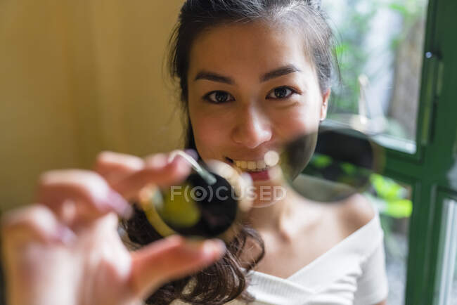 Jeune femme asiatique assis à la table de lecture d'un livre — Photo de stock