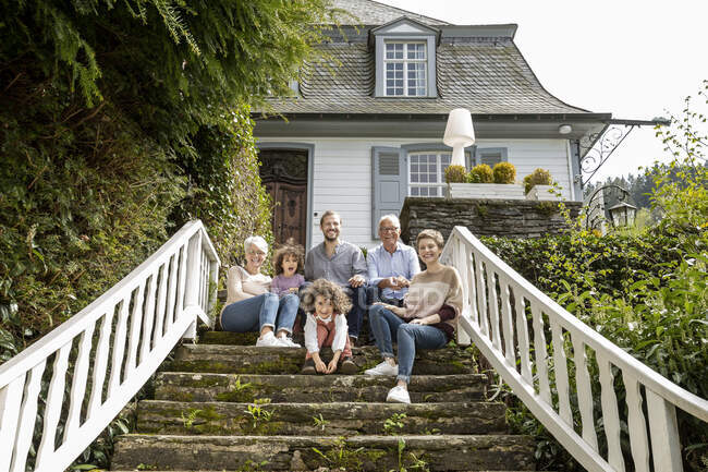 Щаслива родина сидить на сходах у своєму домі. — стокове фото