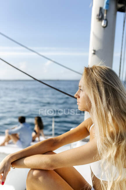 Three young friends enjoying a summer day on a sailboat — Stock Photo
