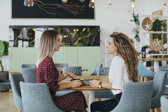 Друзі мають каву і розмовляють в кафе — стокове фото