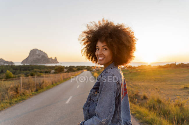 Young woman standing on street and looking at camera at sunset, Ibiza — Stock Photo