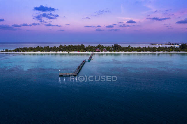 Maldives, Bodufinolhu, Aerial view of jetty of coastal tourist resort on South Male Atoll at dusk — Stock Photo