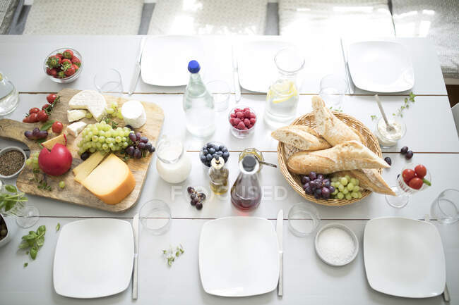 Table dressée avec fruits, fromage et pain — Photo de stock