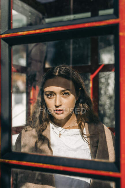 Молода жінка в телефонній коробці, дивлячись на камеру — стокове фото