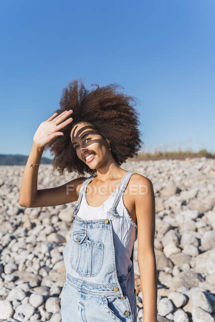 Portrait of young woman on empty beach, raising arm — Stock Photo