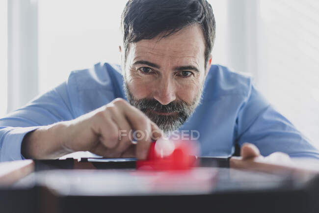 Retrato de un hombre de negocios maduro jugando hockey sobre aire - foto de stock