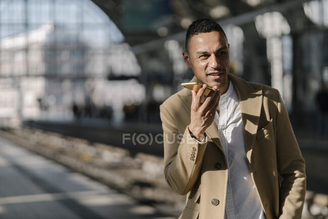Retrato de homem de negócios ao telefone em pé na plataforma da estação ferroviária Alexanderplatz, Berlim, Alemanha — Fotografia de Stock