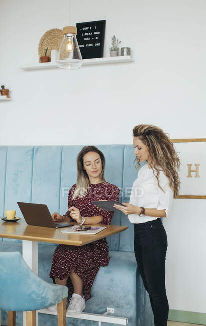 Amigos usando laptop en una cafetería - foto de stock
