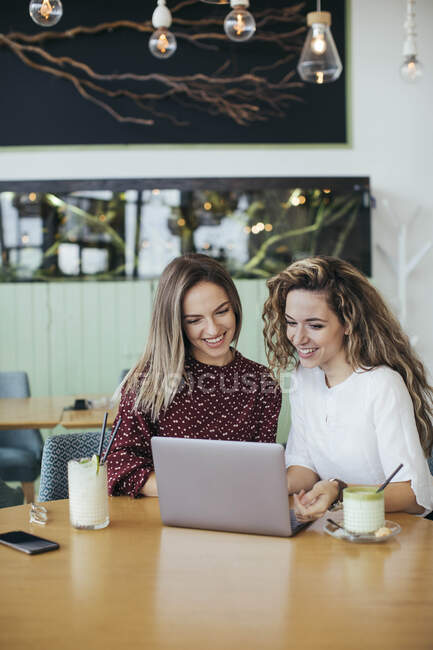 Друзі використовують ноутбук у кафе — стокове фото