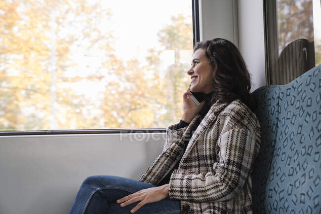 Sorrindo jovem ao telefone em um metrô — Fotografia de Stock