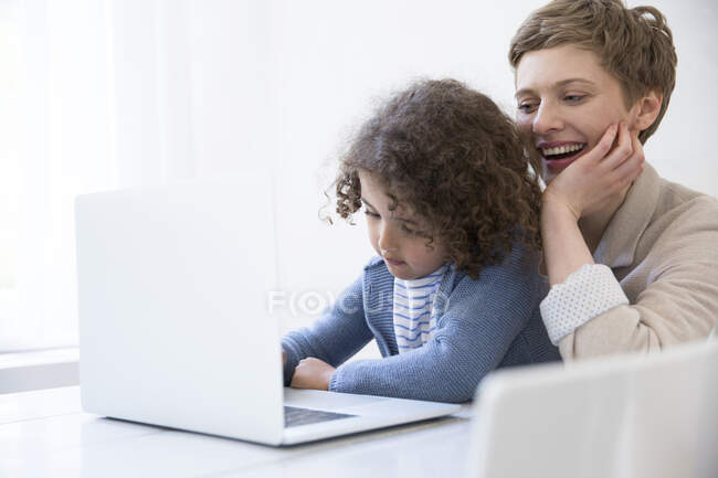 Sorrindo Mãe e filho usando laptop em casa — Fotografia de Stock