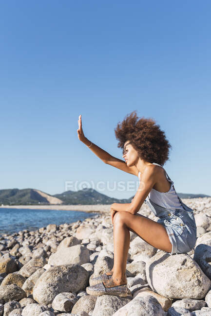 Молодая женщина на пляже, прикрывая глаза рукой — стоковое фото