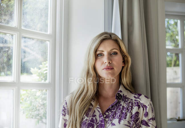 Портрет жінки, що стоїть біля вікна. — стокове фото