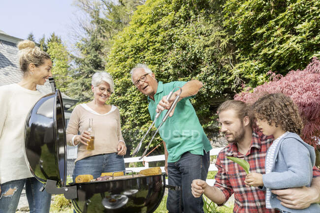 Famiglia allargata che fa un barbecue in giardino — Foto stock