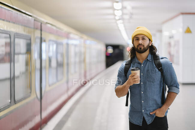 Портрет чоловіка з рюкзаком і кавою, який чекає на платформу (Берлін, Німеччина). — стокове фото