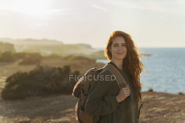 Retrato de una joven pelirroja en la costa al atardecer, Ibiza, España - foto de stock