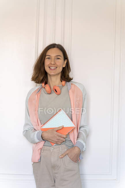 Retrato de una mujer sonriente sosteniendo un cuaderno - foto de stock