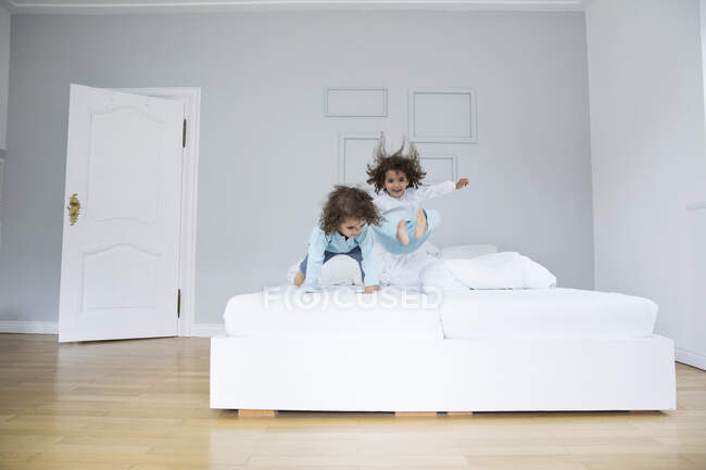 Два грайливі брати - близнюки, які весело проводять час у ліжку. — стокове фото