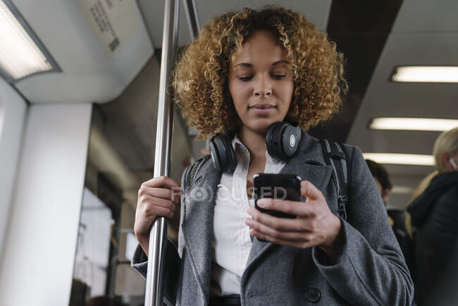 Donna che utilizza smartphone su una metropolitana — Foto stock