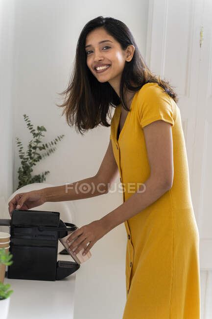 Porrait of smiling young woman making a coffee with coffee machine — Stock Photo