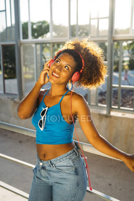 Portrait of smiling young woman listening music with headphones — Stock Photo