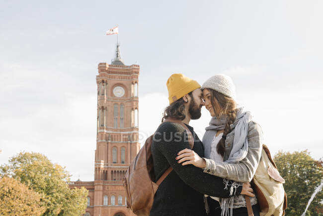 Young couple embracing with Rotes Rathaus in background, Berlin, Germany — Stock Photo