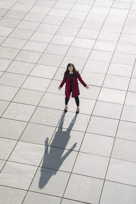 Vista dall'alto di camminare donna d'affari moderna in piedi sul pavimento di cemento con le braccia aperte — Foto stock