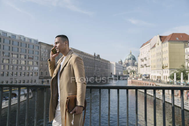 Empresario al teléfono parado en un puente, Berlín, Alemania - foto de stock