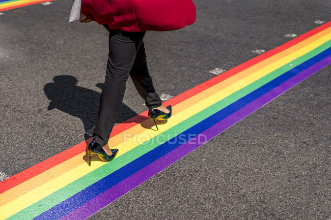 Legs of businesswoman crossing the street on LGBT stripes, London, UK — Stock Photo