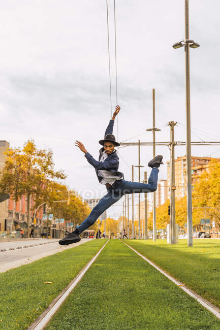 Jovem pulando e dançando em trilhos de bonde — Fotografia de Stock