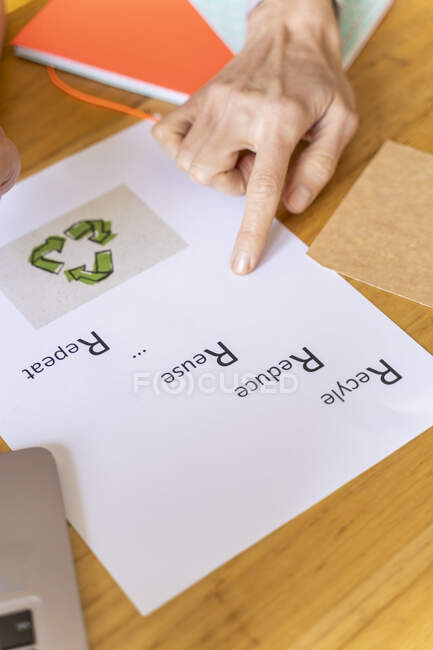 Geschäftsfrau zeigt auf Papier mit Recycling-Symbol im Büro — Stockfoto