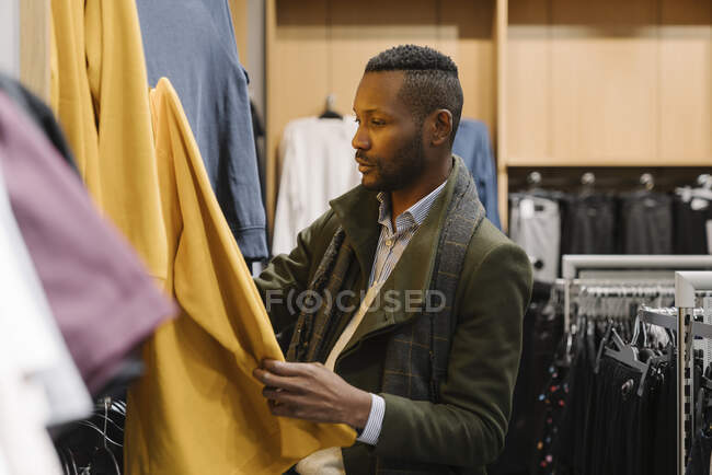 Hombre con estilo de compras en una tienda de ropa - foto de stock