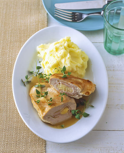Chicken breast stuffed with cheese and ham by mashed potatoes in plate — Stock Photo