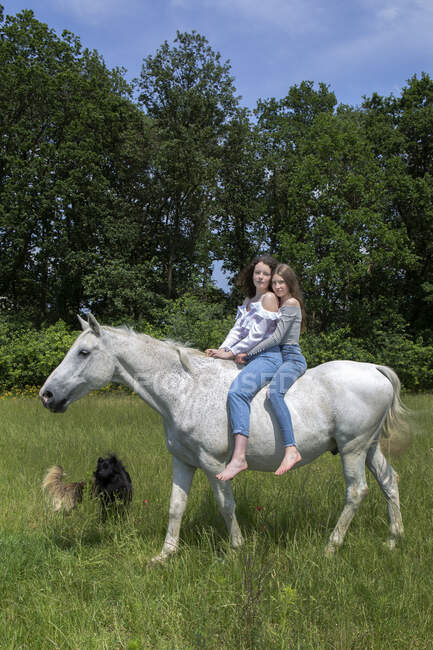 Ritratto di due migliori amici che cavalcano insieme a cavallo — Foto stock