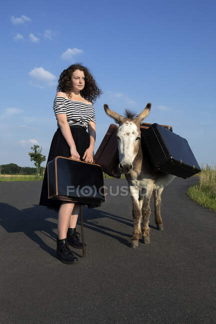 Young woman with her dog on the road — Stock Photo