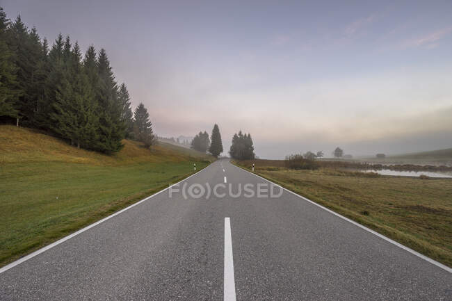 Германия, Бавария, Гармиш-Партенкирхен, Уменьшающаяся перспектива пустого шоссе осенним утром — стоковое фото