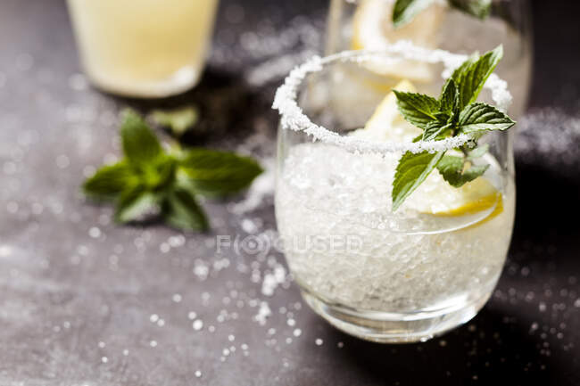 Margarita cocktails with lemon and mint leaves — Stock Photo