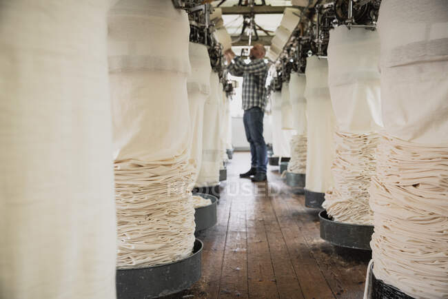 Worker adjusting circular knitting machine, threading yarn — Stock Photo
