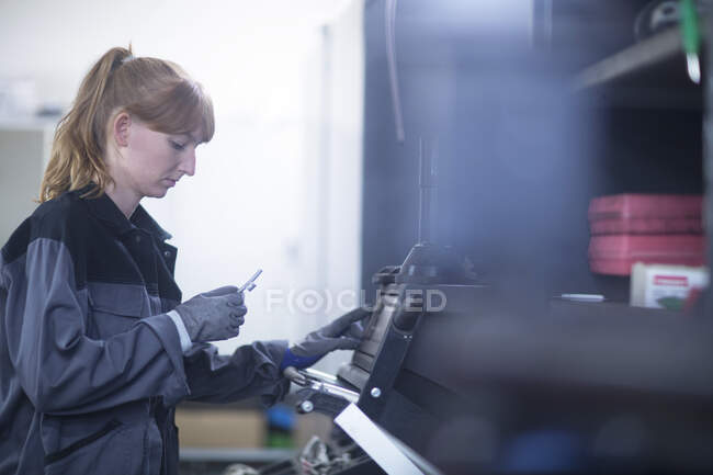 Female car mechanic working in repair garage — Stock Photo
